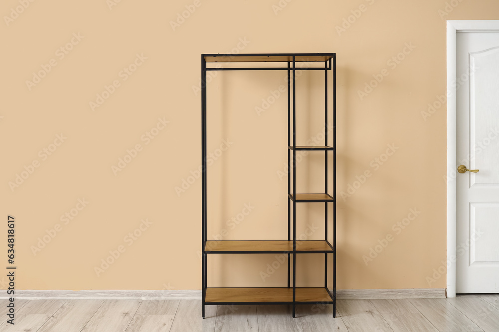 Empty shelving unit near beige wall in room