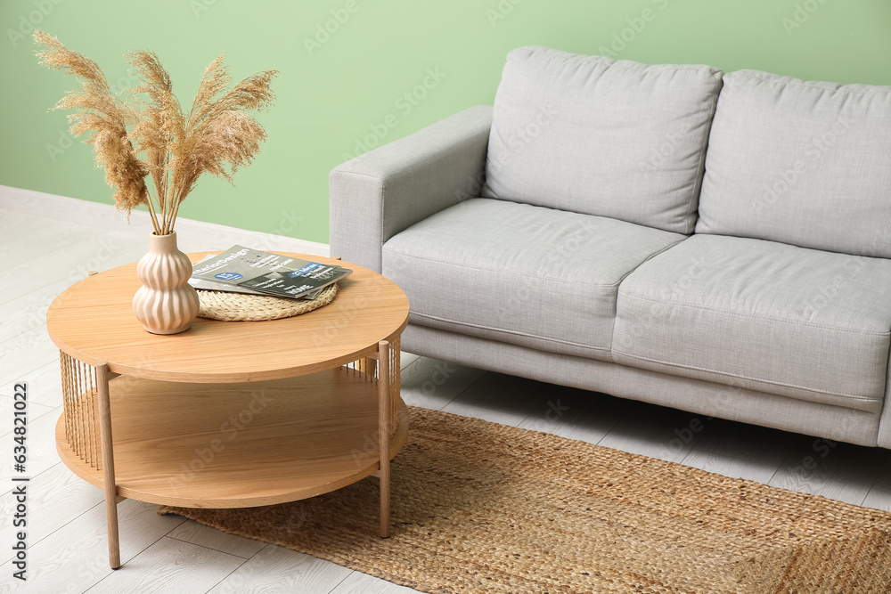 Modern living room interior with comfortable grey sofa and wooden coffee table