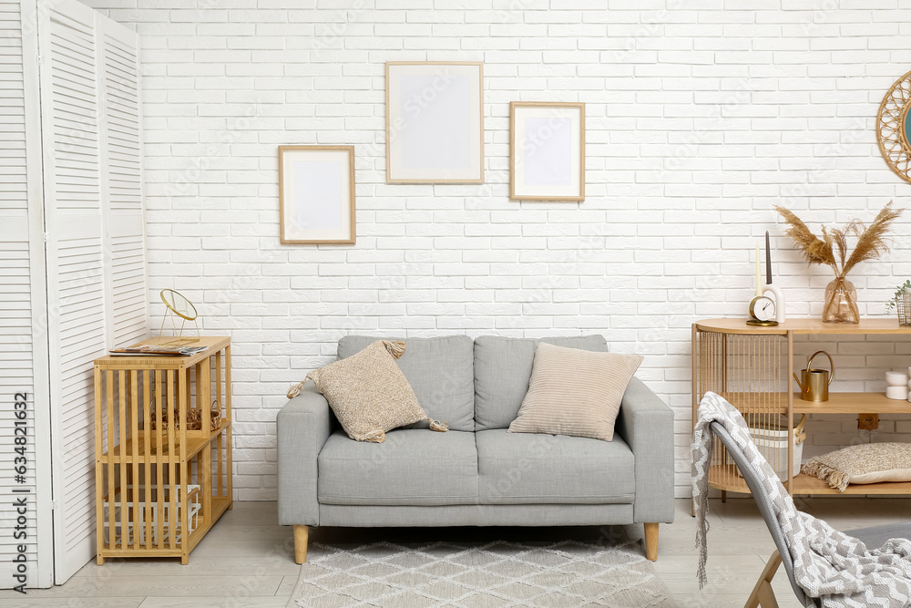 Modern living room interior with grey sofa and shelving units