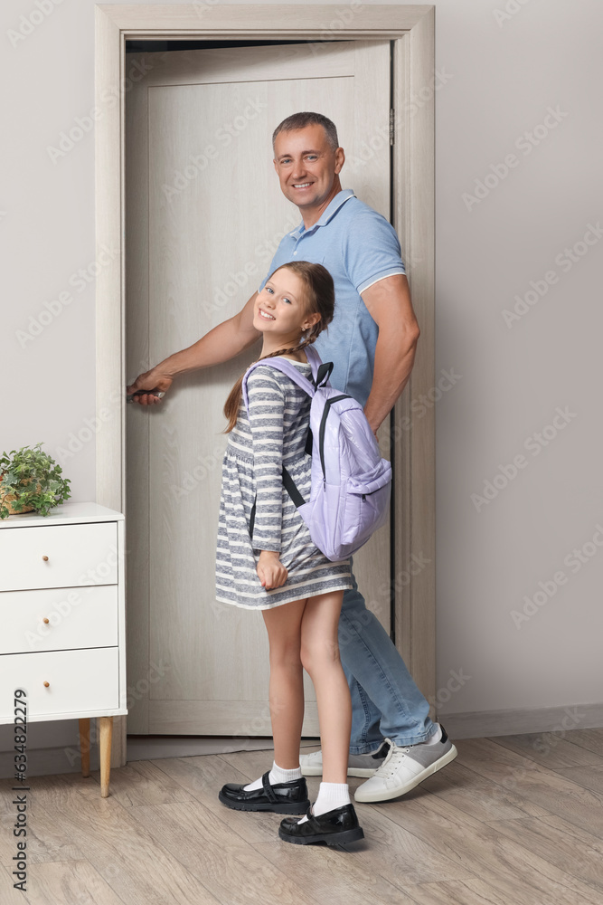 Father walking his little daughter to school in hall