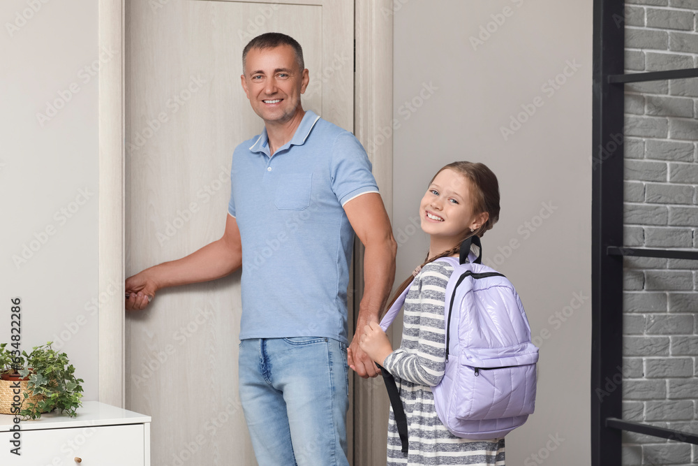 Father walking his little daughter to school in hall