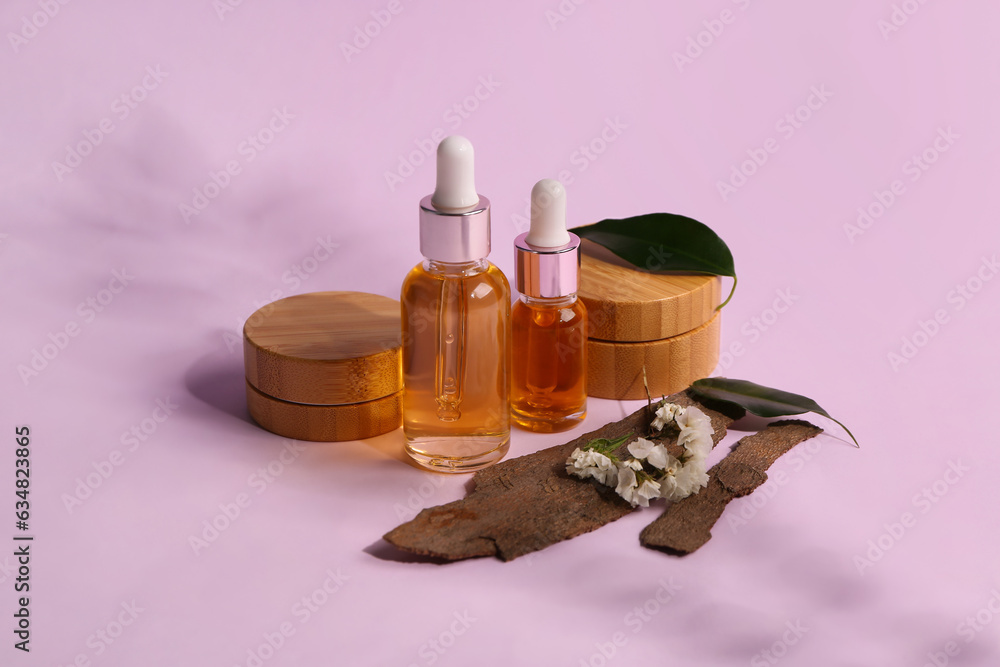 Bottles and jars of cosmetic products with beautiful flowers on lilac background