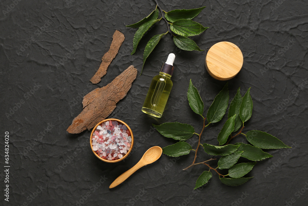 Bottle and jar of cosmetic products with sea salt on black background