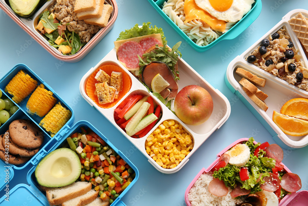 Many lunchboxes with different delicious food on blue background