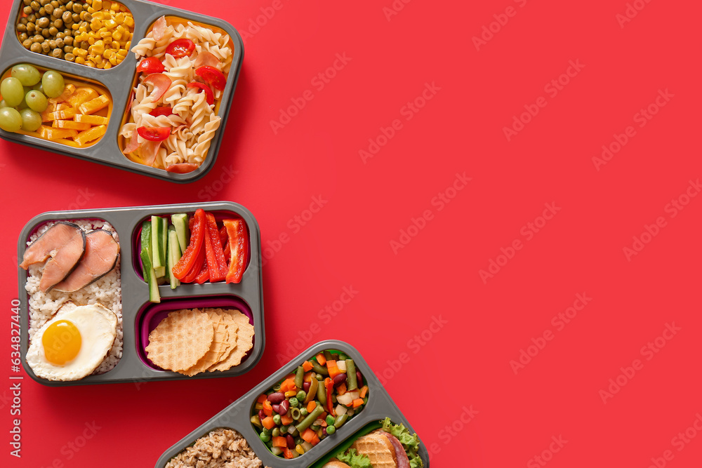 Lunchboxes with different delicious food on red background