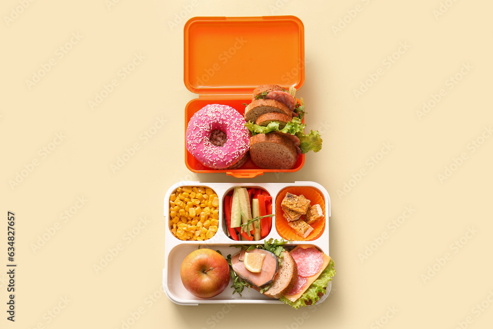 Lunchboxes with different delicious food on pale yellow background