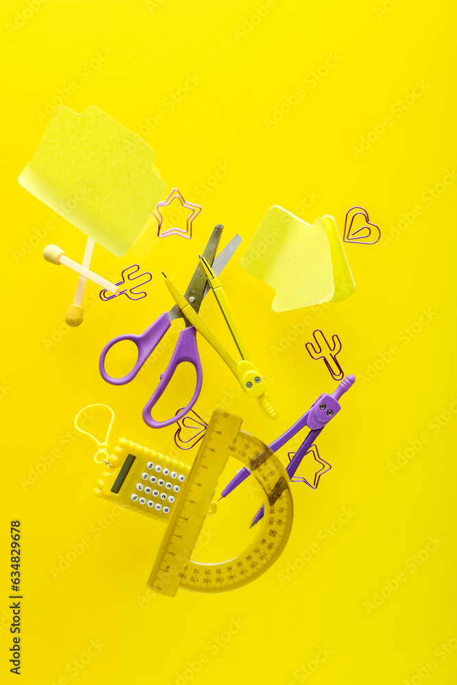 Different stationery flying on yellow background