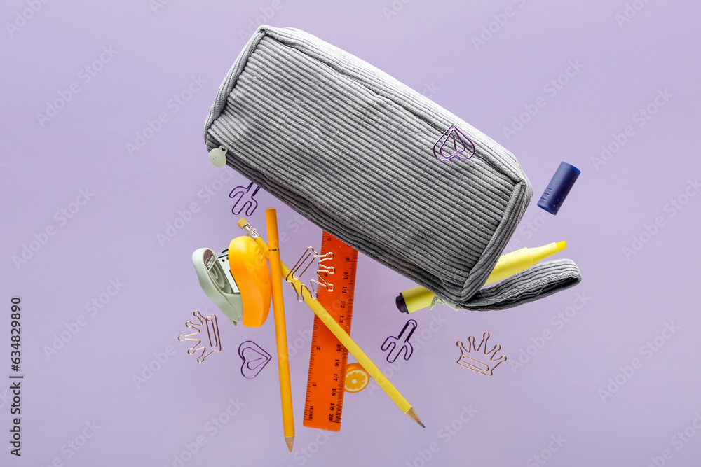 Pencil case with different stationery flying on lilac background