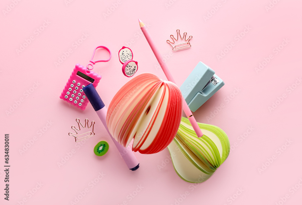 Different flying stationery on pink background