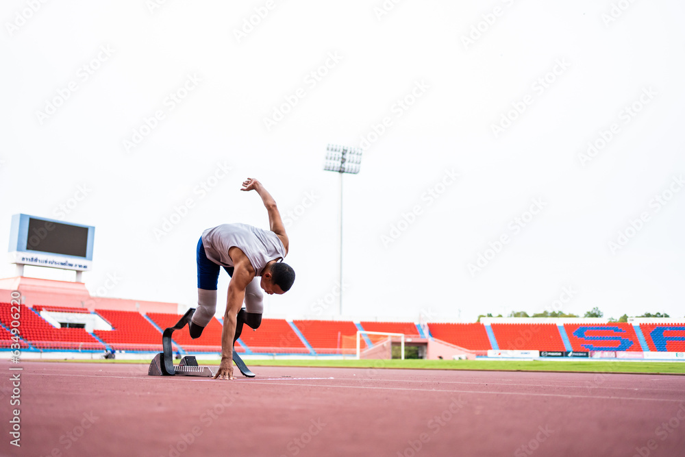 Asian para-athletes disabled with prosthetic blades running at stadium. 