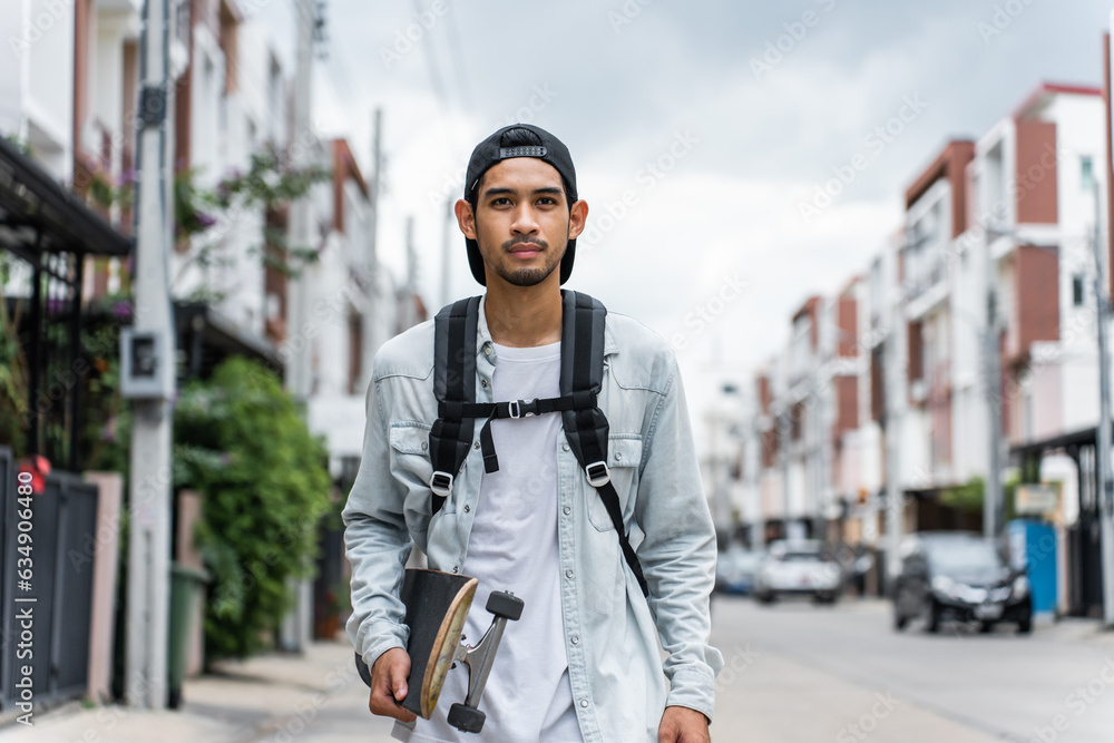 Asian young male ride surf skate board on street on the way to work. 