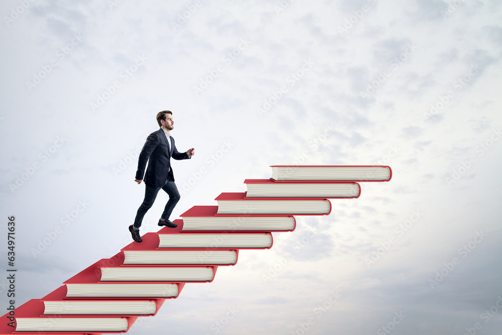 Side view of young businessman climbing red book steps. Cloudy sky background with mock up place. Gr