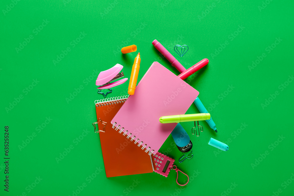 Colorful stationery flying against green background