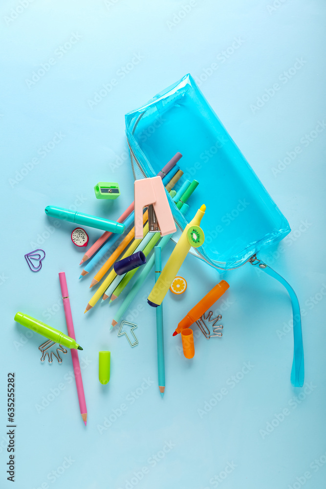 Different stationery and pencil case flying on color background