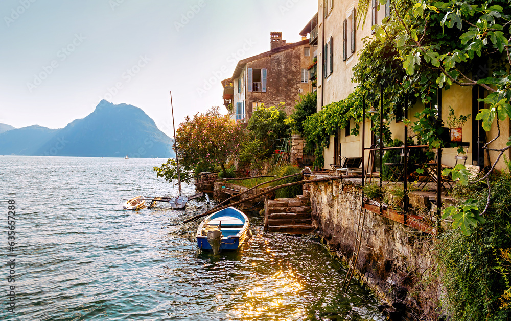 Italy, Lake Lugano. View of the lake, old houses and boat pier