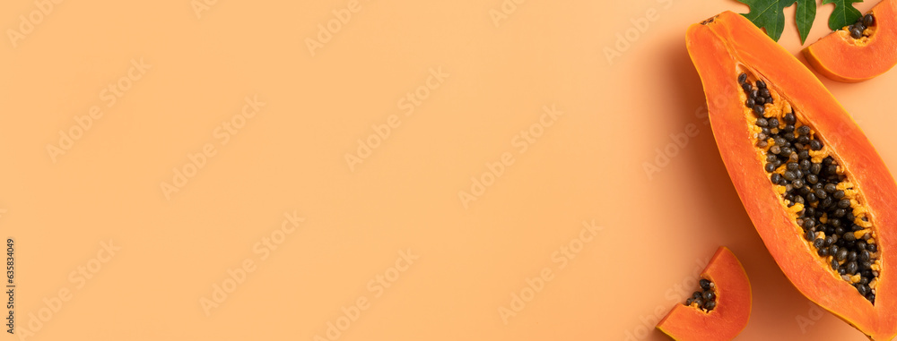 Cut Papaya over orange table background for tropical fruit design concept.