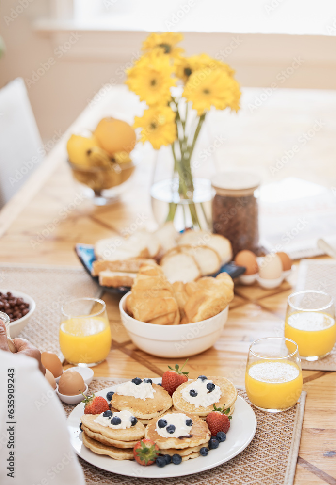 Pancakes, breakfast and orange juice on table in home in the morning. Bread waffle, hands and fruits