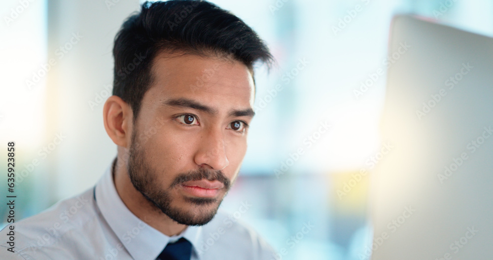 Business man reading his emails and browsing online on a desktop computer while working in an office