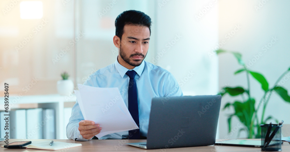 Young man working on his laptop in an office frustrated, stressed and angry about a bad sales report