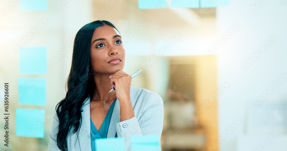 Serious business woman brainstorm project ideas at a board with colorful sticky notes. Female market