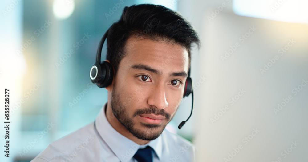 Call center agent talking and listening to a client on a headset while working in an office. Confide