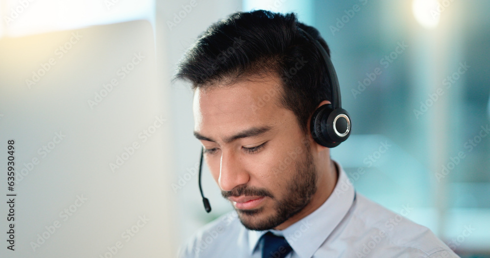 Call center agent talking and listening to a client on a headset while working in an office. Confide