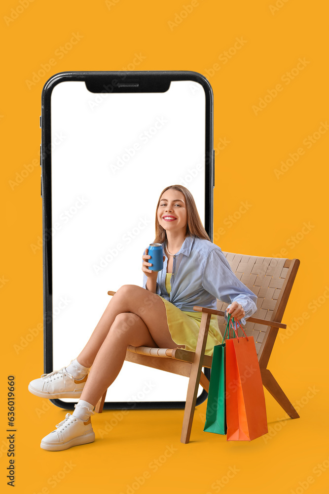 Stylish woman with shopping bags sitting in armchair near big mobile phone on yellow background