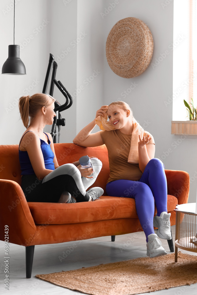 Sporty young women resting after training at home