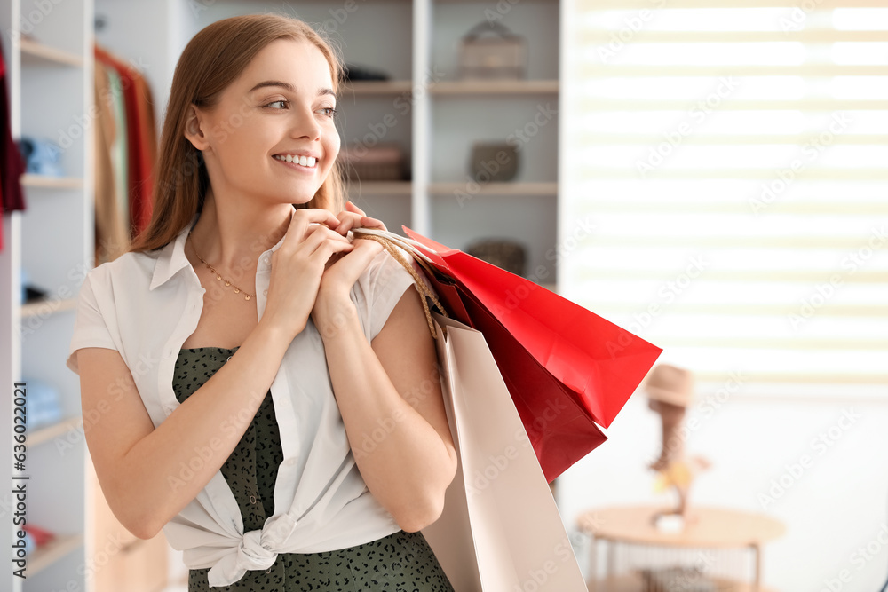 Young woman with shopping bags in boutique