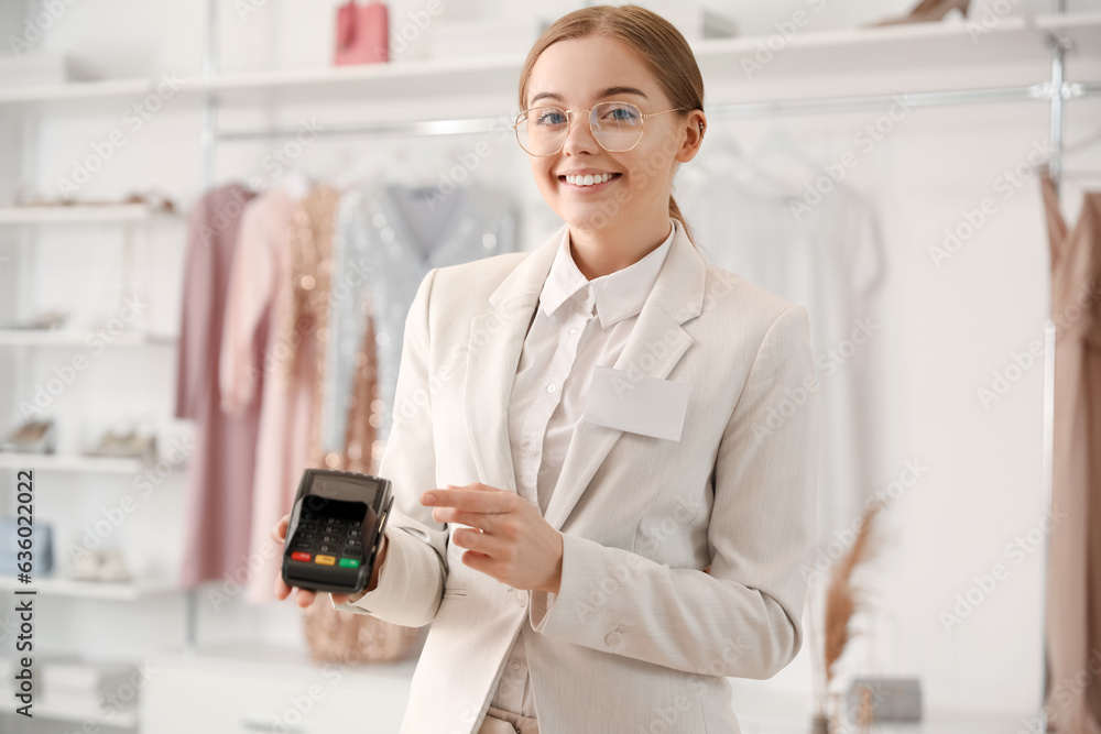 Female seller with payment terminal in boutique