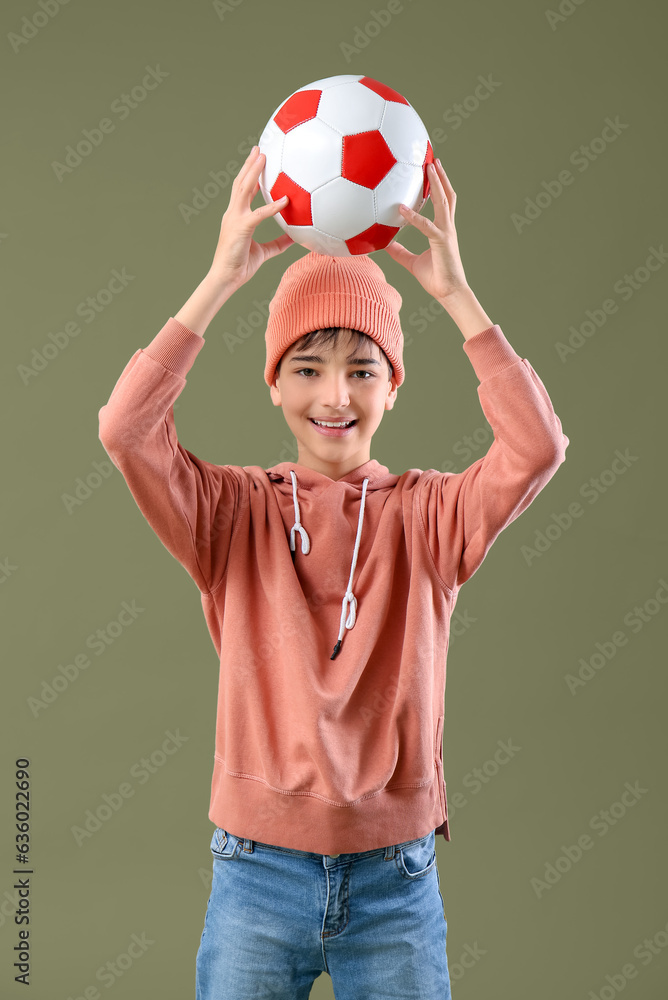 Little boy with soccer ball on color background