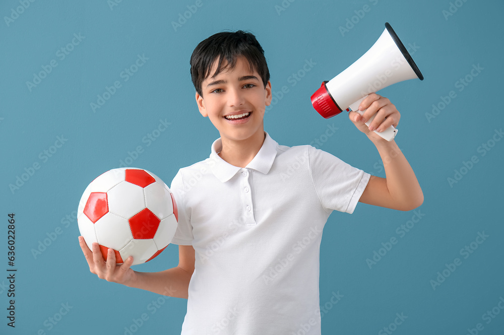 Little boy with soccer ball and megaphone on blue background