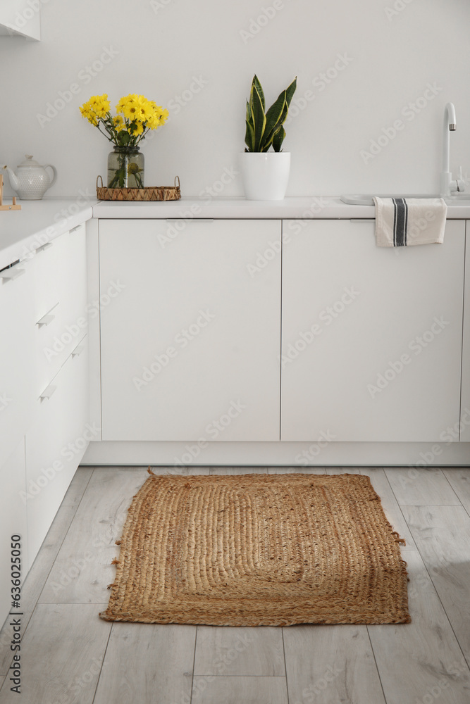 Wicker rug on floor in light kitchen