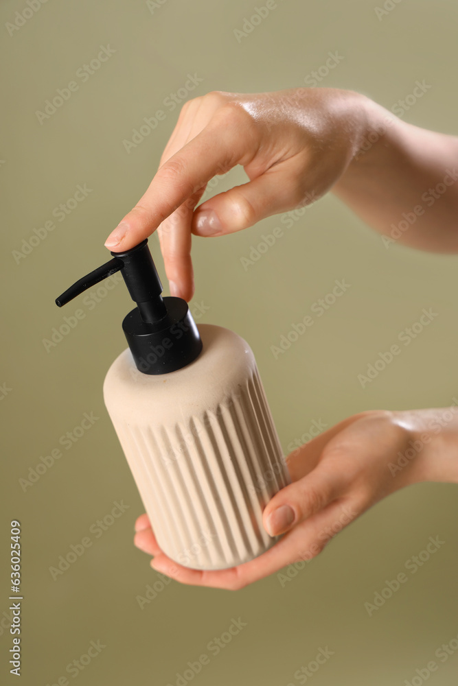 Hands with liquid soap on color background