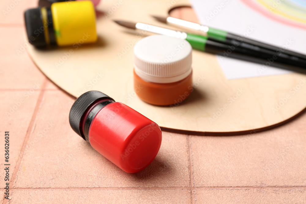 Palette and  paints on beige tile background