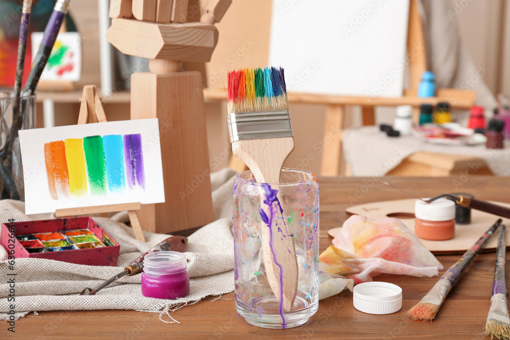 Glass with brush and paints in artists studio