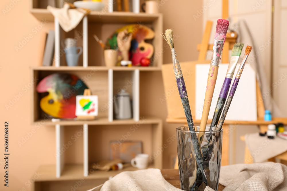 Glass with brushes in artists studio