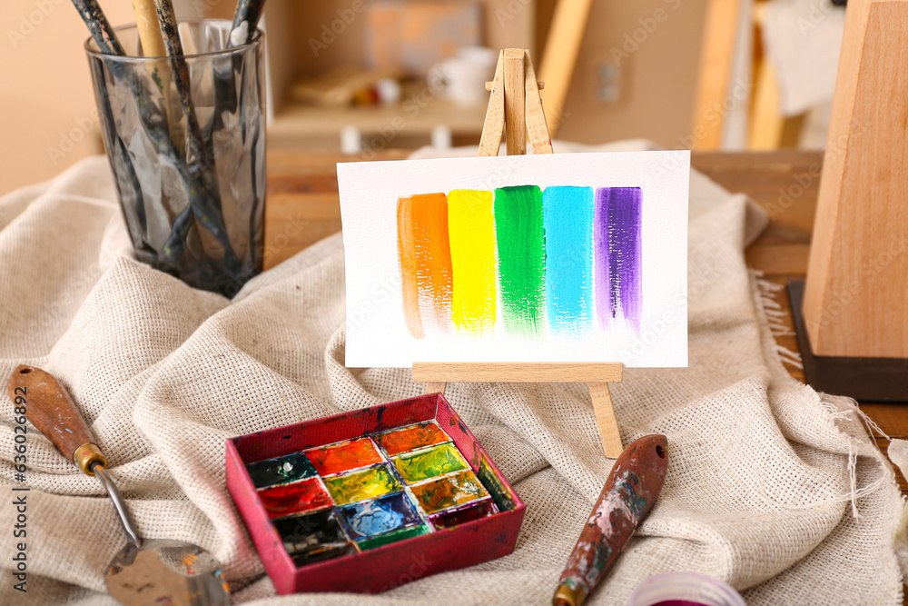 Mini easel with paints strokes in artists studio