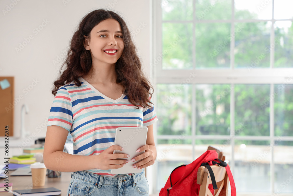 Female student with tablet computer in kitchen