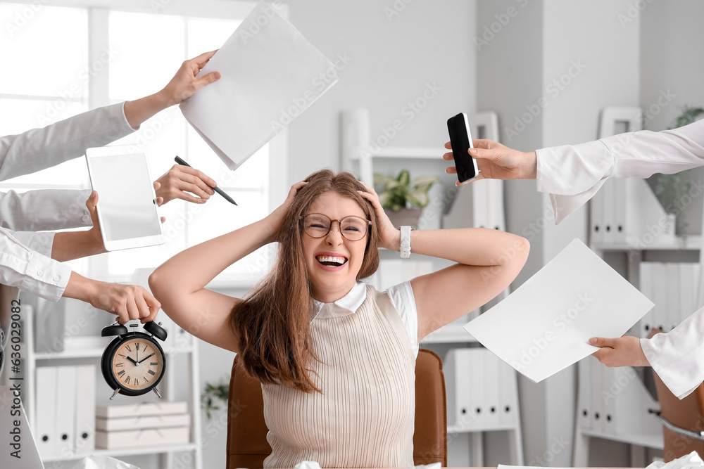 Stressed young businesswoman working under deadline in office