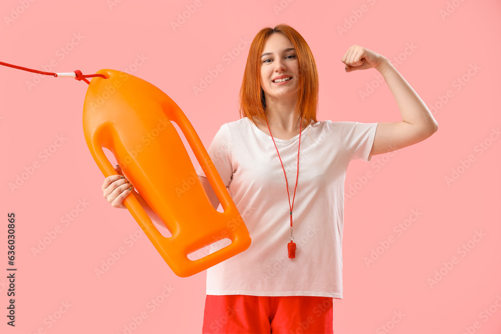 Female lifeguard with rescue buoy showing muscles on pink background