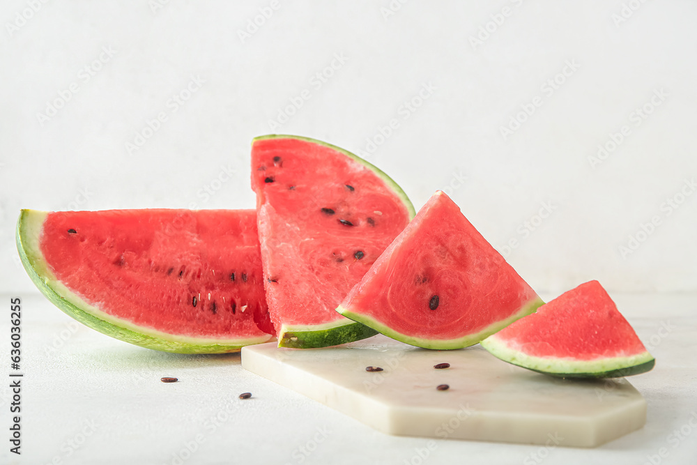 Board with pieces of ripe fresh watermelon on light background, closeup