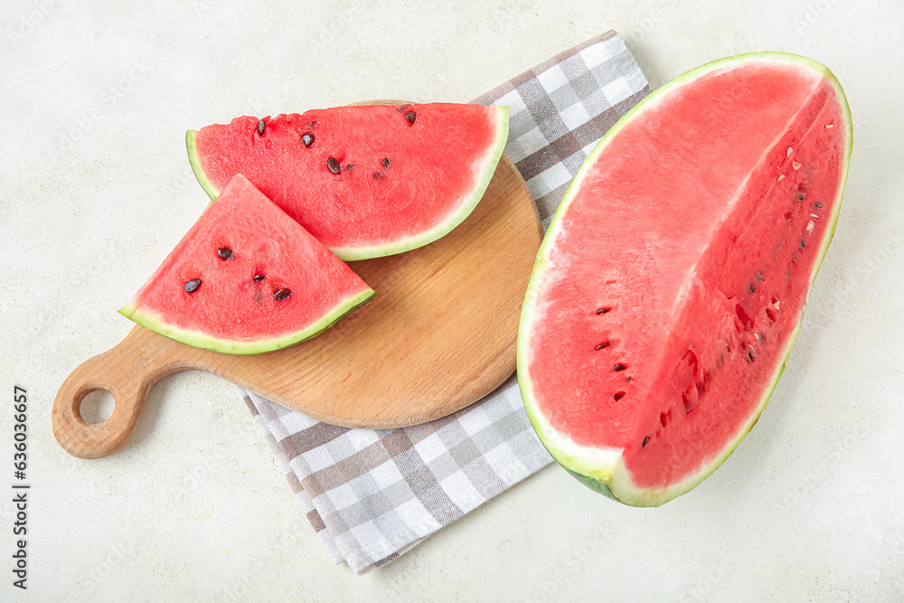 Board with pieces of fresh ripe watermelon on light background