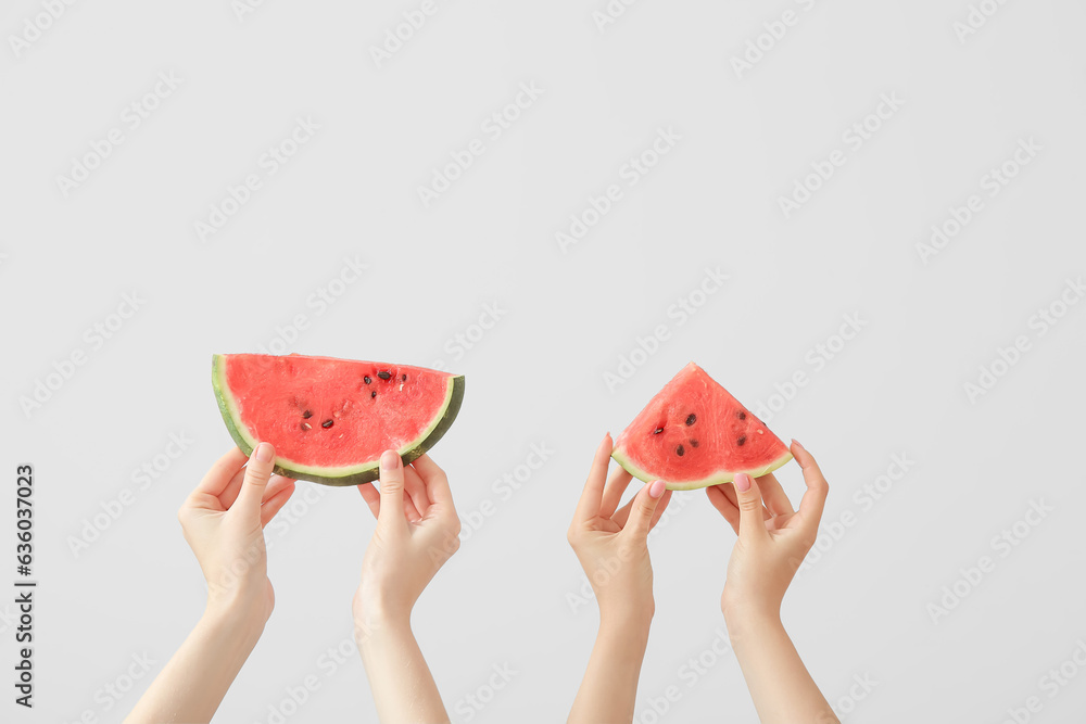 Female hands with pieces of ripe watermelon on white background