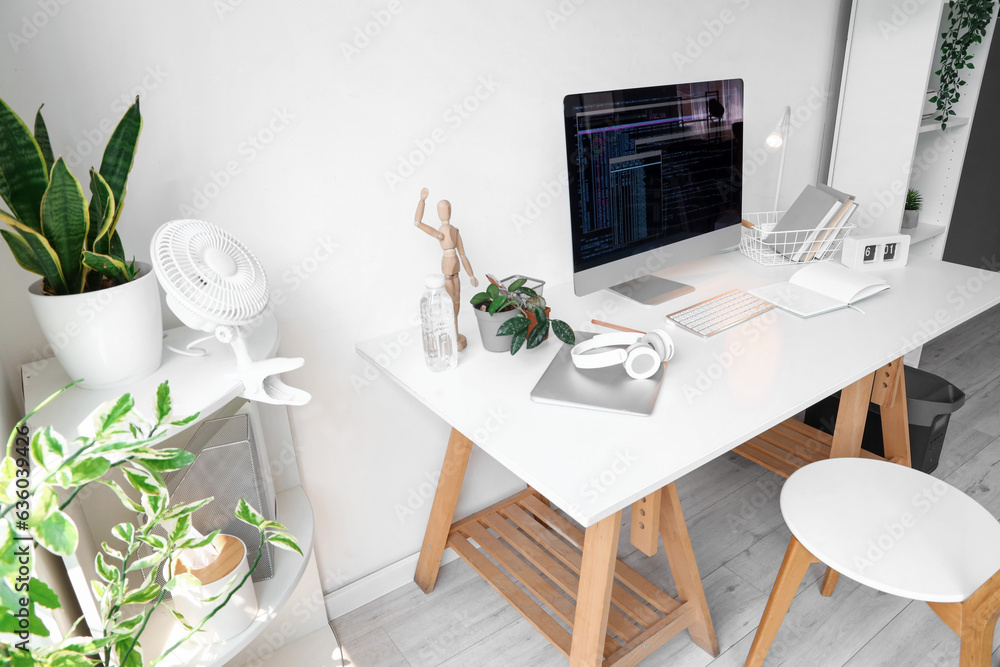 Programmers workplace with computer in interior of light office