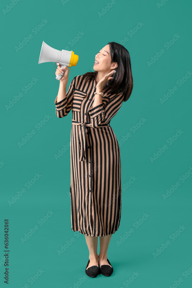 Beautiful Asian woman with megaphone on green background. Dialogue concept