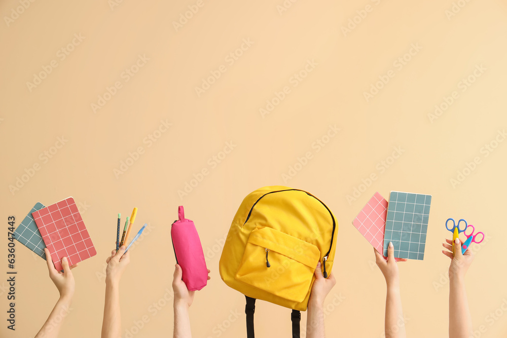 Hands holding school supplies on beige background