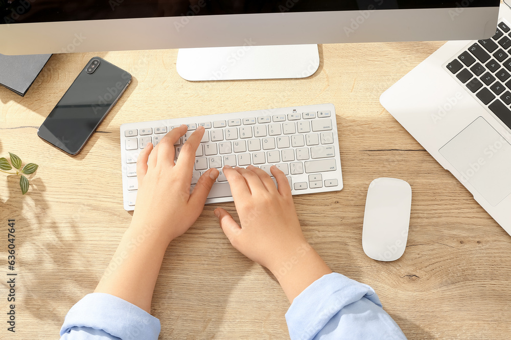 Female programmer typing on computer keyboard in office