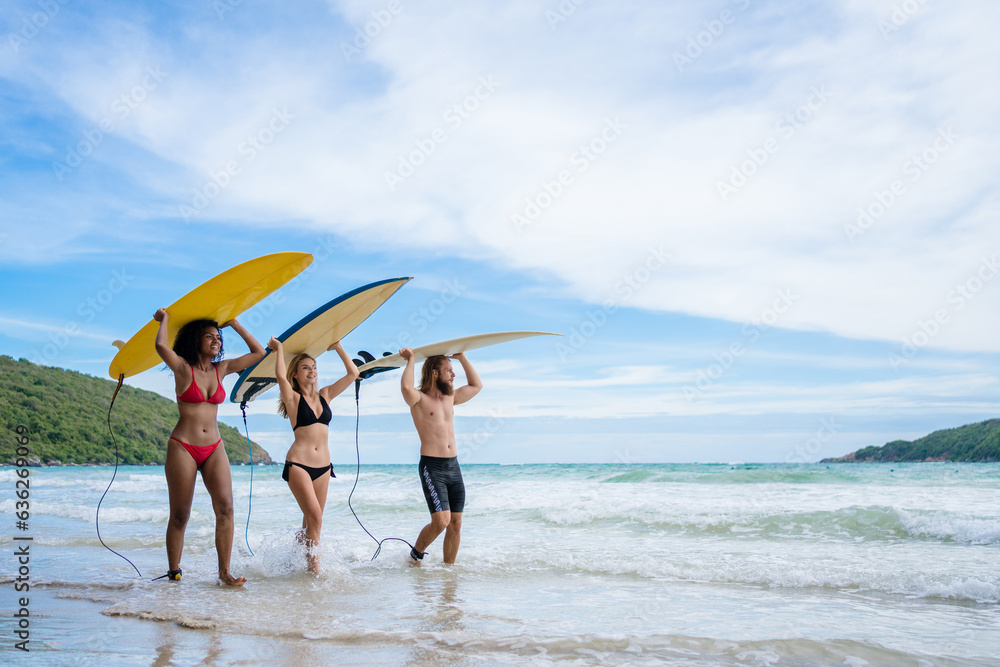 Group Friendship playing surfboard on the beach in weekend activity, Sport extreme healthy lifestyle