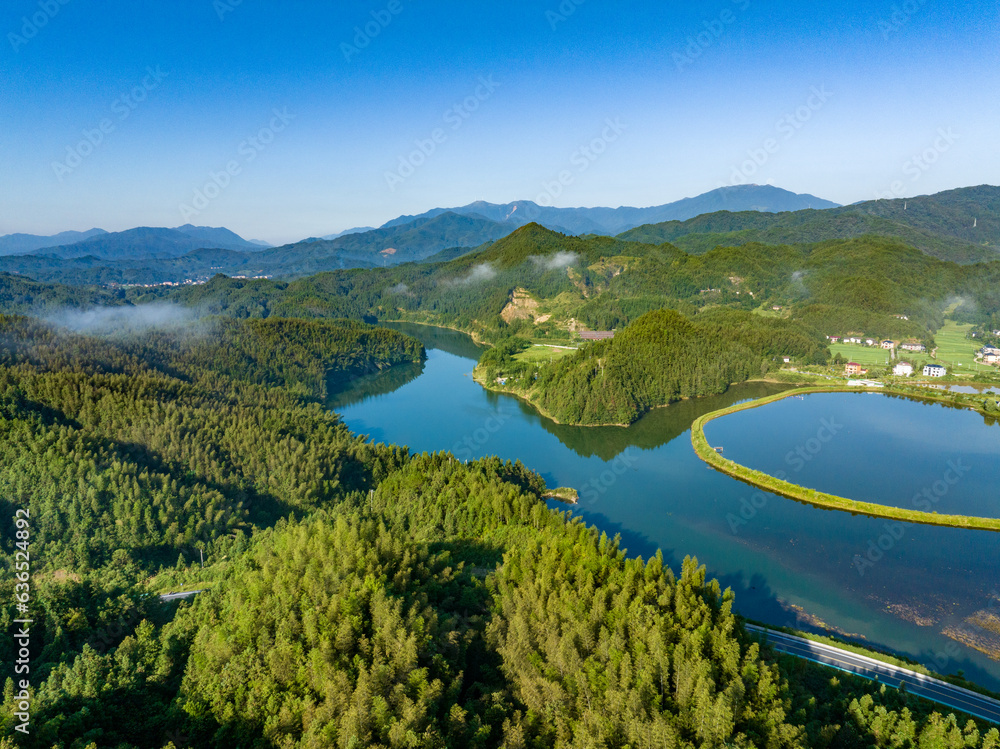 Aerial photography of a large reservoir with blue sky and white clouds and mountains